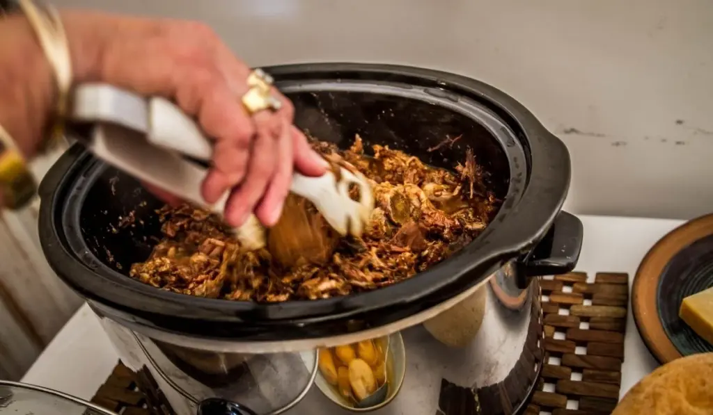 Een slowcooker op het houten aanrecht